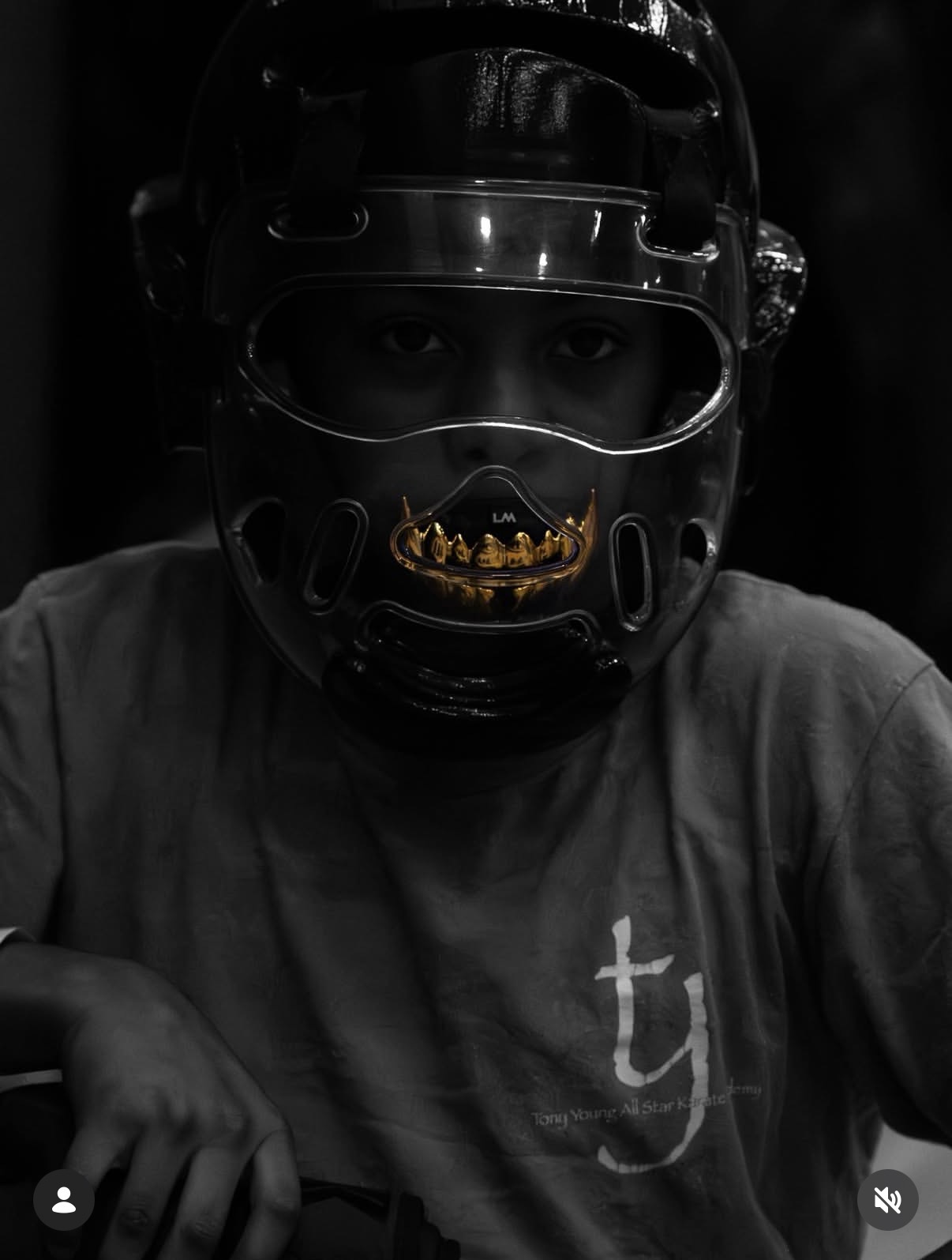 Champ in karate headgear with gold mouthguard, focused before a match